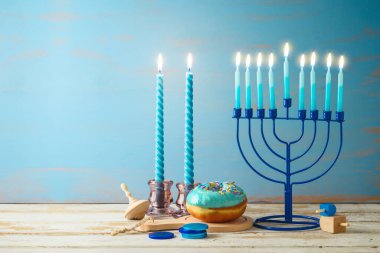 Menoralı Yahudi bayramı Hanukkah konsepti, mumlar ve ahşap masada geleneksel donut. Tebrik kartı veya afiş için arkaplan
