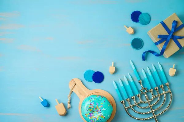 带有传统甜甜圈 薄荷糖和蓝色背景礼品盒的光明节贺卡 — 图库照片