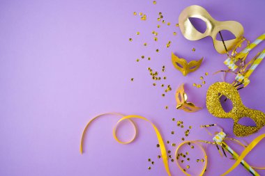 Carnival or mardi gras concept with golden carnival masks on violet background. Top view with copy space