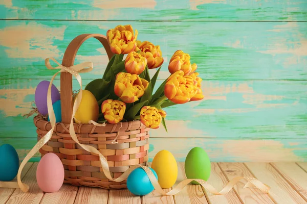 复活节作曲 用复活节彩蛋和郁金香花在木制桌子上的篮子里 节日庆祝贺卡 — 图库照片