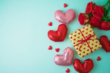 Kalp şekilli ve mavi arka planda hediye kutusuyla Sevgililer Günü için yağlı beste. Üst görünüm