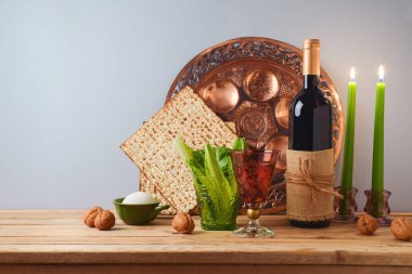 Yahudi bayramı bayramı kutlaması konsepti şarap, matza ve ahşap masa üzerindeki gri arka planda. Geleneksel Pesah tablo ayarı pankartı