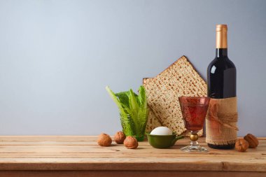 Yahudi bayramı bayramı konsepti şarap, matza ve ahşap masa üzerinde ceviz ile gri arka planda..