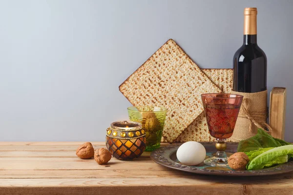 ユダヤ教の休日灰色の背景に木製のテーブルの上にワイン マツァとセダープレートと過越のお祝いの概念 — ストック写真
