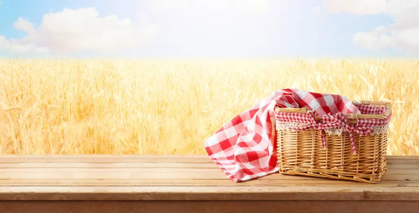 Empty Picnic Basket Tablecloth Wooden Table Wheat Field Landscape Background — Zdjęcie stockowe