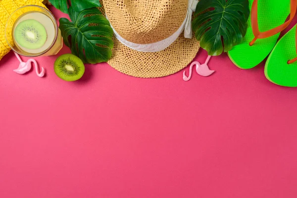 Summer holiday vacation concept with beach accessories and tropical leaves on pink background. Top view, flat lay