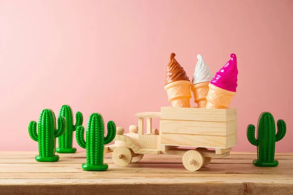 ピンクを背景に木製のテーブルの上におもちゃのトラック アイスクリームやサボテンと夏休みのコンセプト — ストック写真