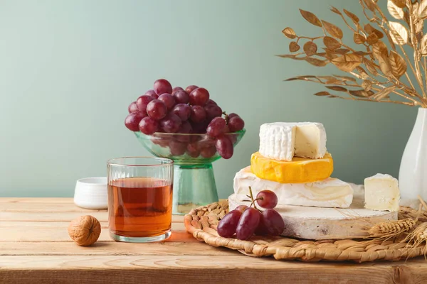 Stillleben Komposition Mit Käse Trauben Nüssen Und Wein Auf Holztisch — Stockfoto