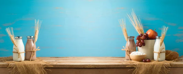 ユダヤ人の休日青い背景の上に木製のテーブルの上に新鮮な果物 ミルクボトル コテージチーズとShavuotコンセプト — ストック写真
