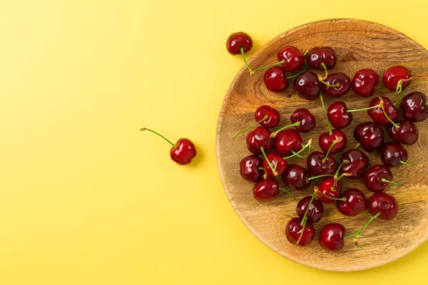 Summer Food Concept Red Cherries Wooden Plate Yellow Background — Zdjęcie stockowe