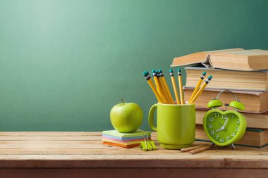 Kitapları, elmaları ve kalemleri olan öğrenci masası. Okul geçmişine dönelim.