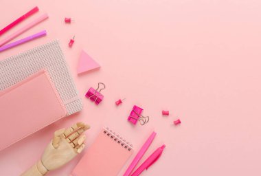 Stylish pink workplace with notebook and stationery. Background for back to school concept. Top view, flat lay