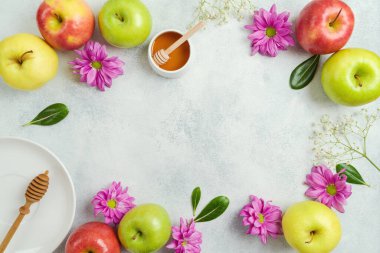 Border frame background for Jewish holiday Rosh Hashanah. Festive table setting with apples, honey and flowers. Top view, flat lay