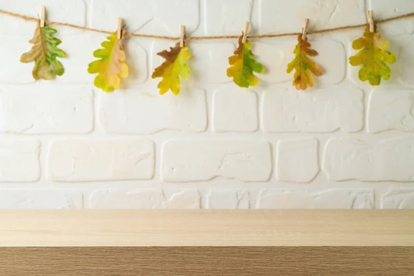 Prázdný Dřevěný Stůl Přes Cihlovou Zeď Podzimní Listy Girland Pozadí — Stock fotografie