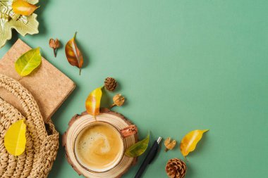 Boho merkez ofis işyeri. Kahve fincanı, planlayıcı, çanta ve yeşil arka planda sonbahar yaprakları. Üst manzara, düz uzanma