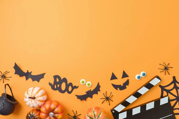 Halloween horror movie night background  with  pumpkin, decorations and movie clapper board. Top view, flat lay