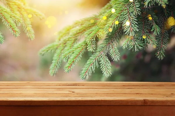美しい緑のモミの木の枝の上に空の木製のテーブルと冬の背景 クリスマス休暇 デザインと製品の表示のためのモックアップ — ストック写真