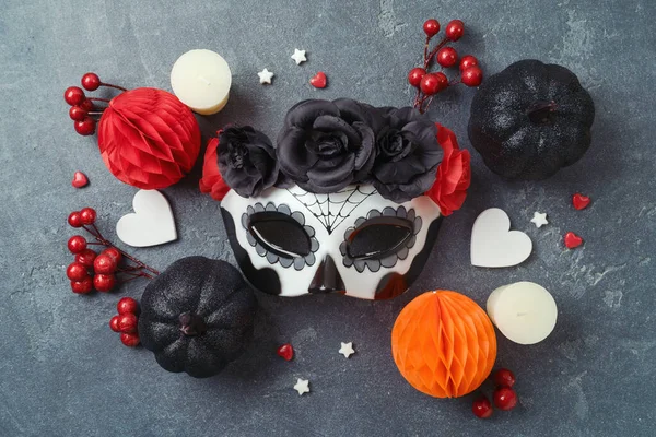 Sugar skull mask and Mexican party decorations  flat lay composition. Da de los Muertos day of the dead holiday concept.