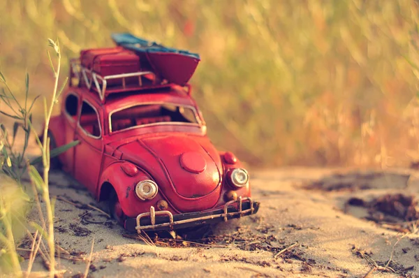 Coche de juguete con equipaje en la playa de arena — Foto de Stock