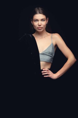 Siyah arka planda siyah şapkalı güzel bir kızın moda stüdyo portresi. Alçak tuş.