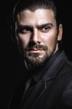 Sert erkek portresi. Klasik siyah takım elbiseli adam. Yarı yüz ışıkta.
