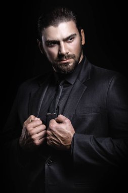 Sert erkek portresi. Klasik siyah takım elbiseli adam. Yarı yüz ışıkta.