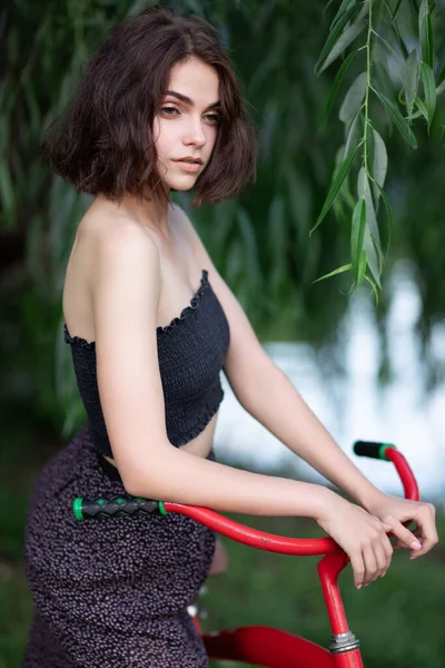 자전거를 매혹적 머리새는 공원에서 자전거를 다닌다 드레스와 윗옷을 프랑스 여인의 — 스톡 사진