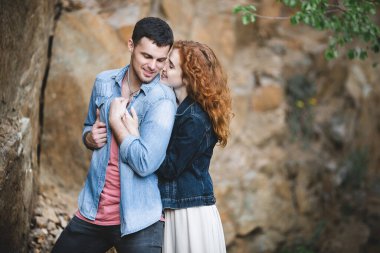 Taş bir uçurumun arkasında güzel bir çift. Birbirini seven bir çiftin portresi.