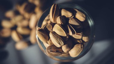 Fıstıklı fıstık. Durgun hayat. Büyük bir şarap kadehinde şam fıstığı. Fıstık, yakın çekim.