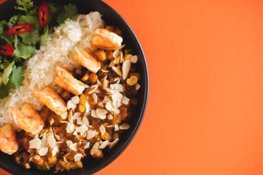 Asya mutfağı. Körili pirinçli karides. Turuncu arka planda iştah açıcı bir yemek.