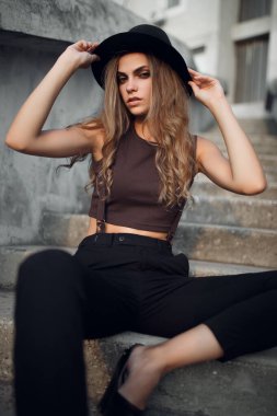 Sokağın arka planında şapkalı güzel, çekici bir kadın. yaz moda trendi