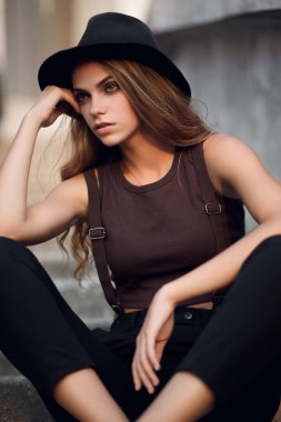 Sokağın arka planında şapkalı güzel, çekici bir kadın. yaz moda trendi