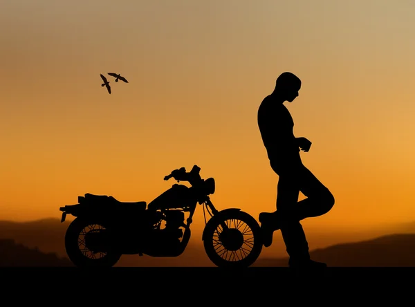 Силуэт человека с мотоциклом — стоковое фото
