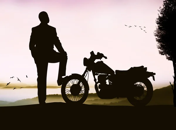 Silhouet van een man met een motorfiets — Stockfoto