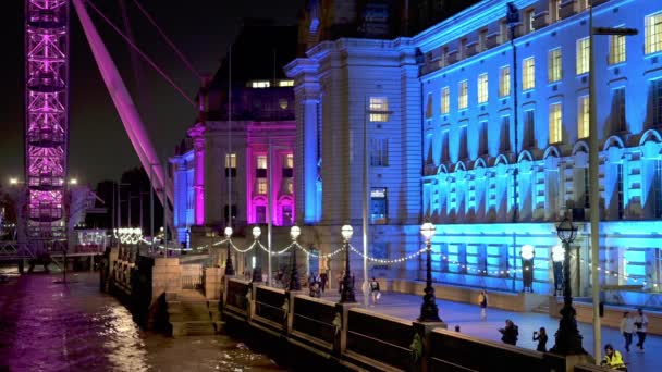 ロンドン 2021年9月14日 ロンドン アイとカウンティ ホールの間のサウスバンクのカラフルな夜のシーンは ウェストミンスター橋から見られるように — ストック動画