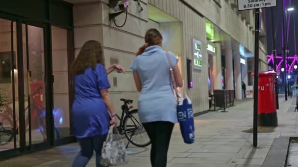 Londýn Září 2021 Dvě Ženy Procházejí Noci Kolem Zaparkovaného Elektrického — Stock video