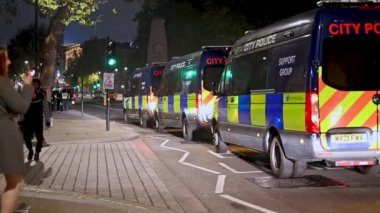 5 Kasım 2021, Whitehall 'da Milyon Maske Yürüyüşü' nde iki kadın bir dizi polis aracını geçti.