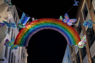 NOVEMBER 1, 2021: Renkli gökkuşağı ve kelebek süslemeleri Noel için Carnaby Caddesi üzerinde asılı