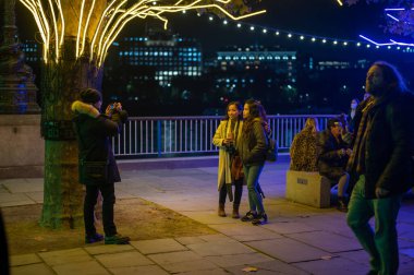 5 Kasım 2021 'de müşteriler, Southbank Noel süslemelerinin altında bir fotoğraf için poz verdiler.