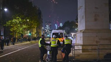 NOVEMBER 5, 2021: Çevik Kuvvet ve Polis minibüsü, Milyon Maske Yürüyüşü 'nün arka planında havai fişeklerle Whitehall' daki Cenotaph 'ın yanında