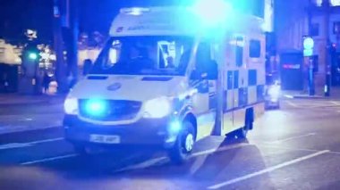 LONDON - 5 Kasım 2021: Mavi ışıklı bir ambulans Trafalgar Meydanı 'nda gece trafiğinde hızla ilerliyor