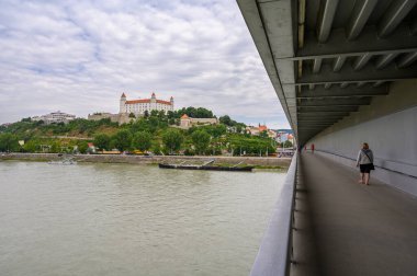 BRATISLAVA, SLOVAKIA - 9 Temmuz 2019: Bratislava Şatosu ve Tuna Nehri SNP köprüsü üzerinde yaya yolu boyunca görüldü