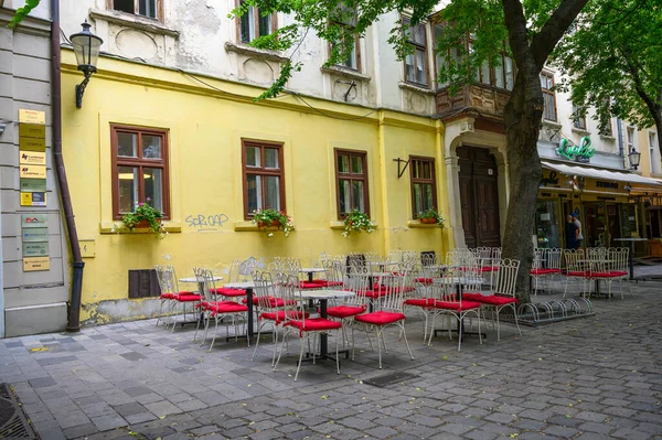 BRATISLAVA, SLOVAKIA - 9 Temmuz 2019: Bratislava 'da ağaçlarla kaplı bir yemek alanında boş masa ve sandalyeler