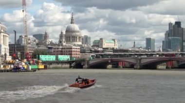 LONDON - 24 AĞUSTOS 2018: E Sınıfı Thames nehri boyunca, Londra, İngiltere boyunca finans bölgesi Blackfriars Köprüsü 'ne doğru yol alan ve arka planda dramatik bulutlu bir gökyüzü bulunan cankurtaran botu.