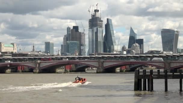 2018年8月24日 E级近岸救生艇驶向英国伦敦泰晤士河上的布莱克弗赖斯桥 以金融区和乌云密布的天空为背景 — 图库视频影像