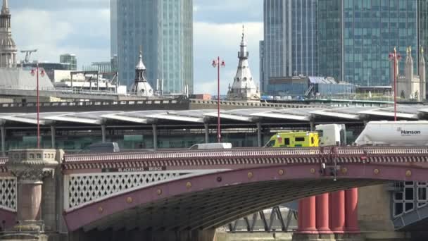 ロンドン 2018年8月24日 ロンドンのスカイラインと背景に劇的な曇りの空を持つテムズ川を明らかにするために Blackfriars Bridgeの交通で開催された緊急時対応救急車からズームアウト — ストック動画