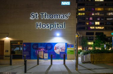 LONDON - May 17, 2022: Illuminated St Thomas' Hospital sign on side of building at night