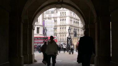 LONDON - 18 Mayıs 2022: Silüet içindeki insanlar arka planda kırmızı Londra çift katlı otobüslerle At Muhafızları Geçidi 'ne giriyorlar