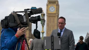 Londra - 14 Eylül 2022: TV haber ekibi Kraliçe 2. Elizabeth 'in ulusal yas sırasında Westminster Köprüsü' nden Parlamento önünde bildiriyor.