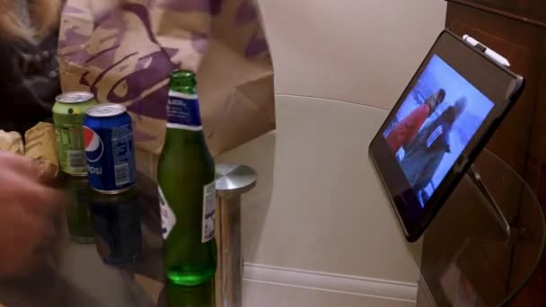 2022年5月18日 运动时间 吃东西的人在平板电脑上看电视时带走食物 照相机在玻璃桌上升起 — 图库视频影像